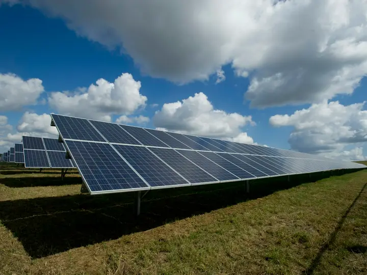 Usina de placas solares sob céu com nuvens