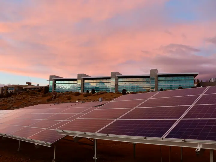 Placas solares em área comercial ao entardecer